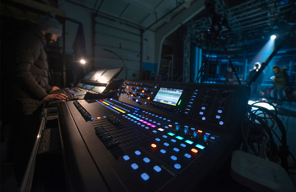 Event sound operator behind sound board for a blog about live event audio visual production